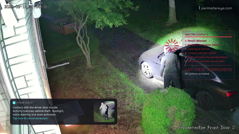 The searchlight lighting the person at the driver’s door, with the car theft in progress panel and the phone alert